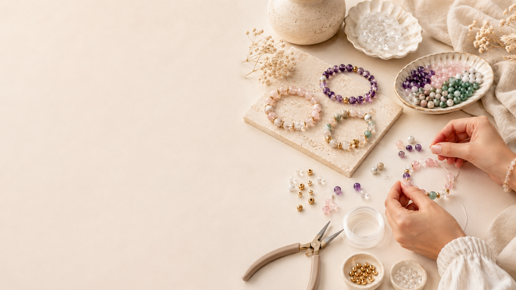 Jewelry-making activity with beads, bracelets, and pliers on a light surface.