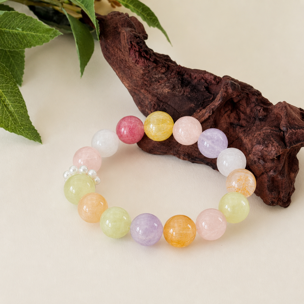 Rainbow crystal stretch bracelet on driftwood with green leaves botanical styling